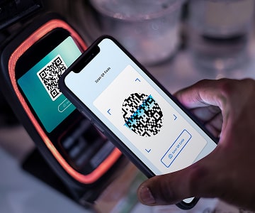 Smartphone scanning a QR code for cashless payment